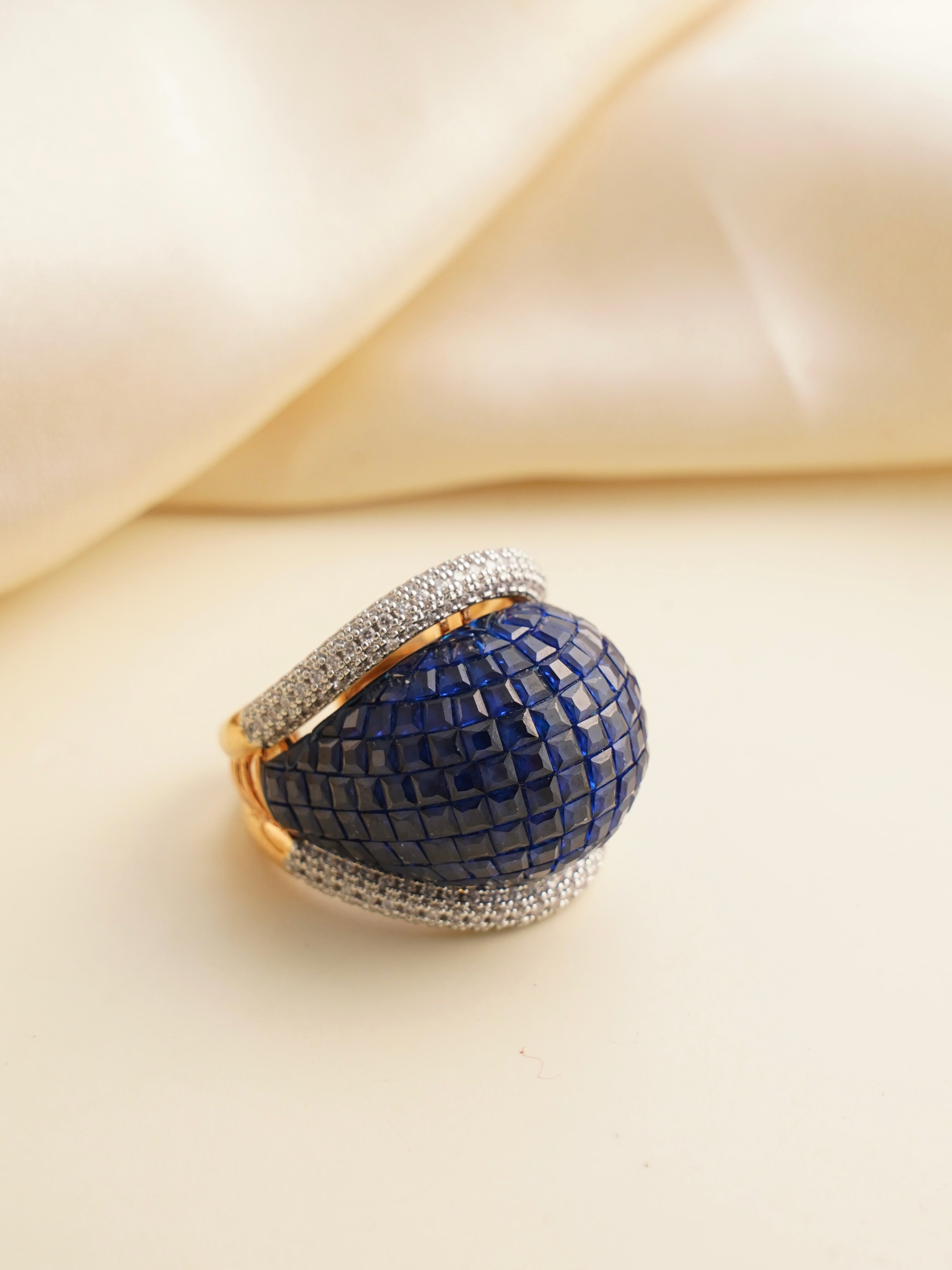 Front view of midnight blue mosaic gemstone ring with gold-plated base and pave diamonds
