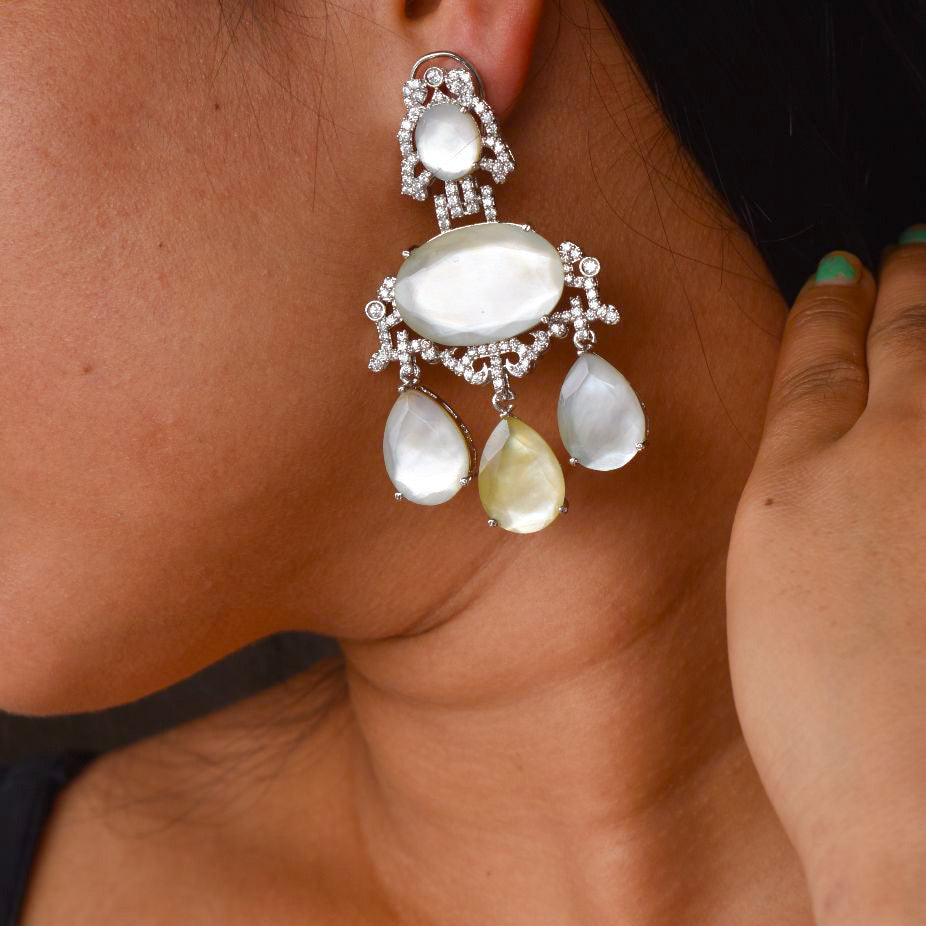 Side angle of statement chandelier earrings with layered gemstone drops