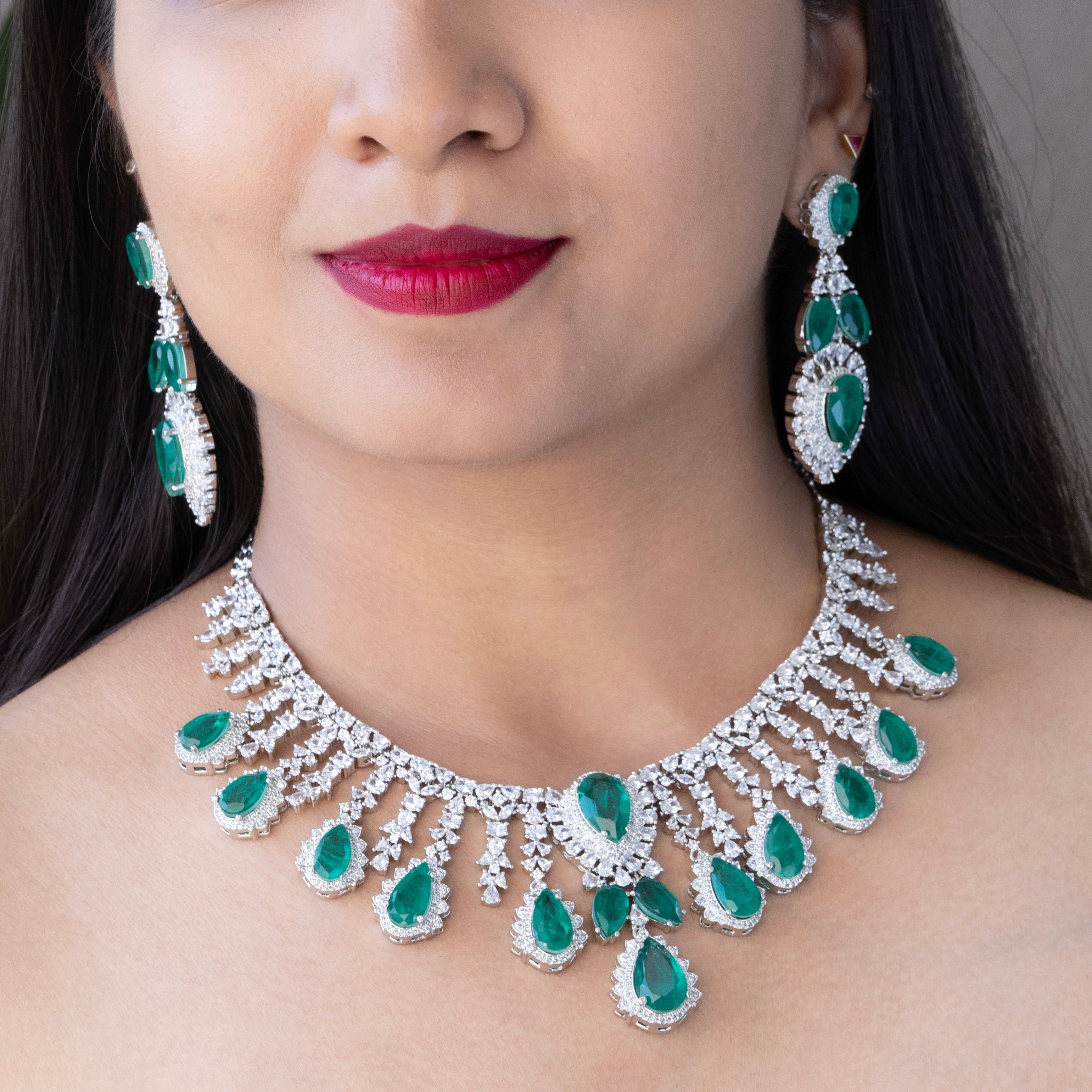 Luxurious emerald necklace and earring set with vivid green stones and bold finish