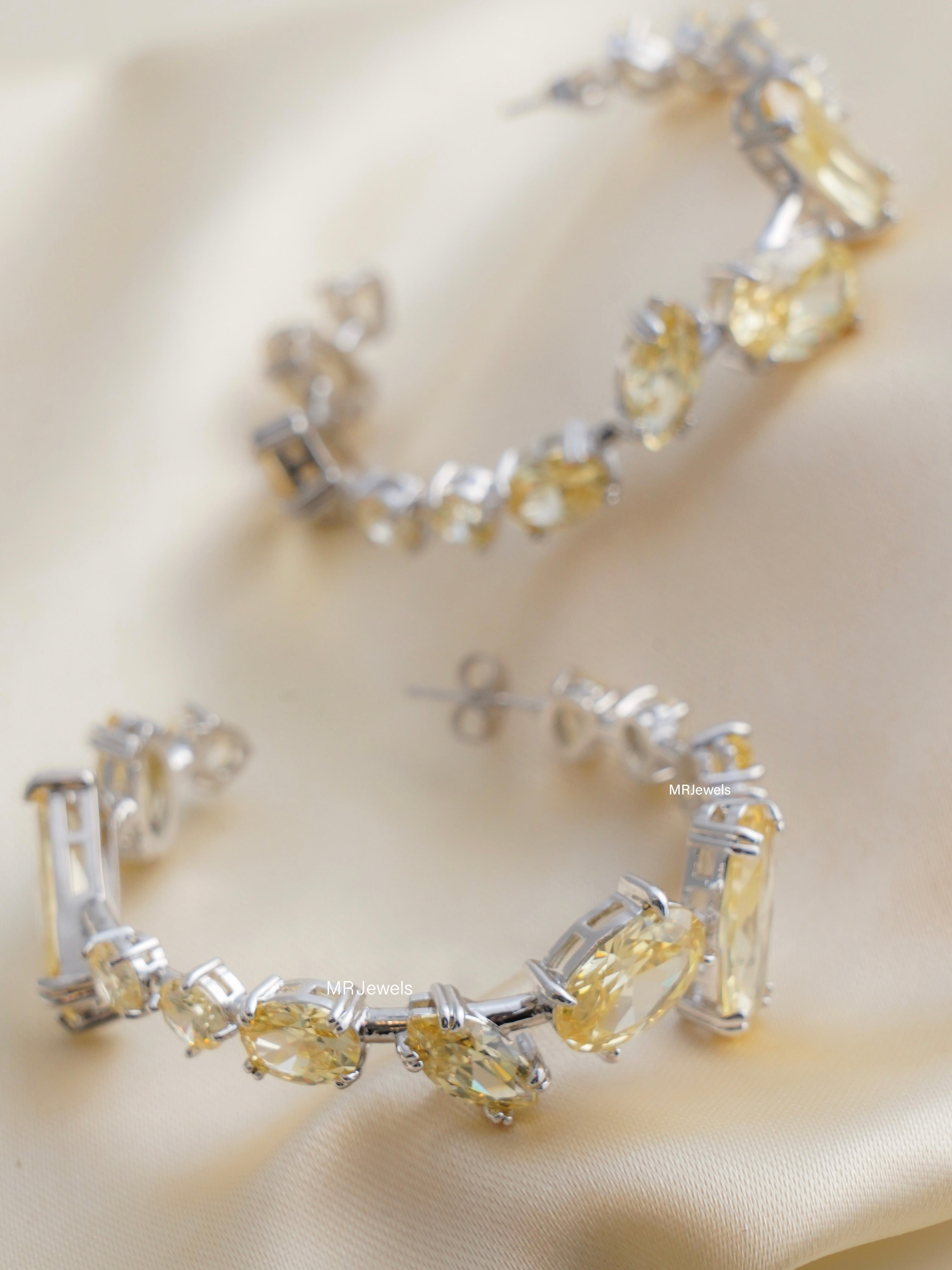 side angle of multicolor swarovski crystal hoops sparkling with rainbow hues