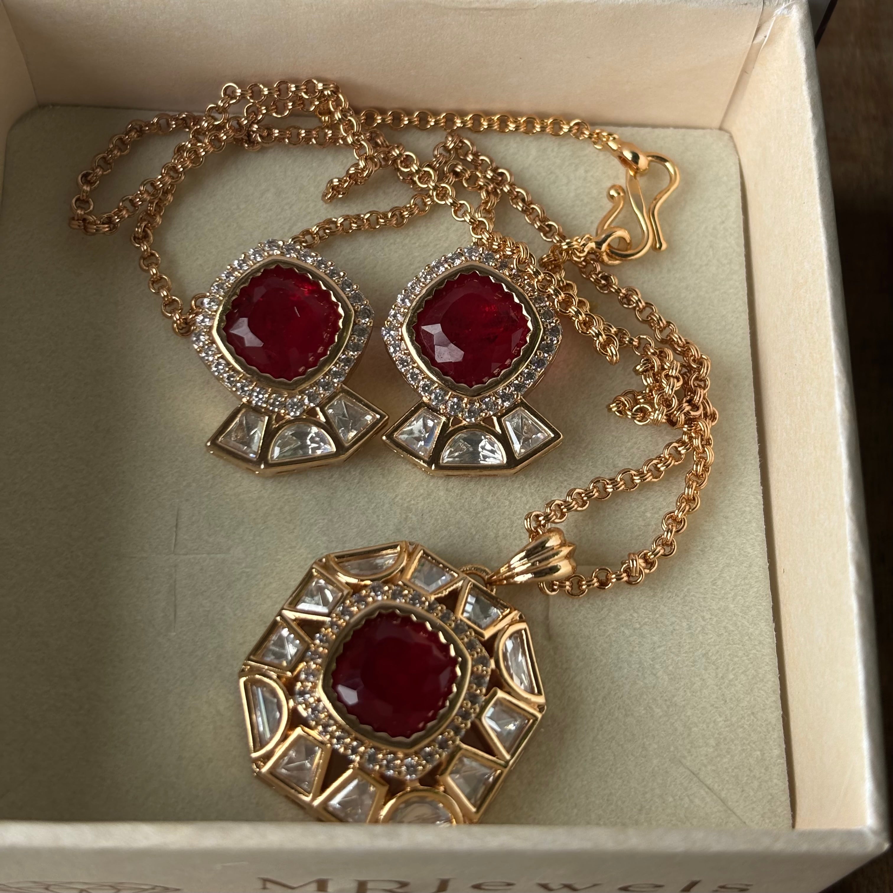 Side view of statement earrings with red stones and intricate gold finish