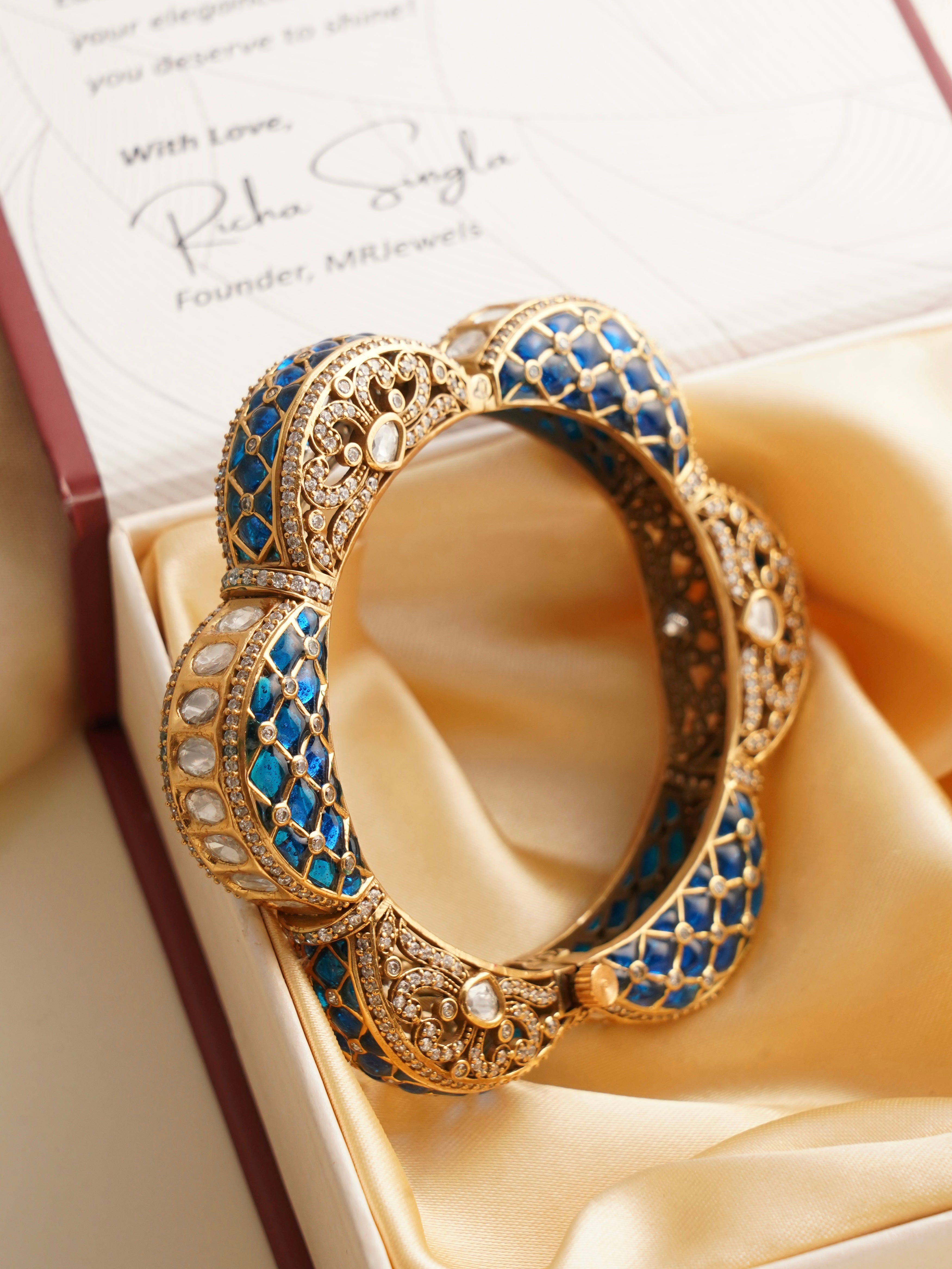 Side view of floral-inspired polki kada with ruby, emerald, and kundan stonework