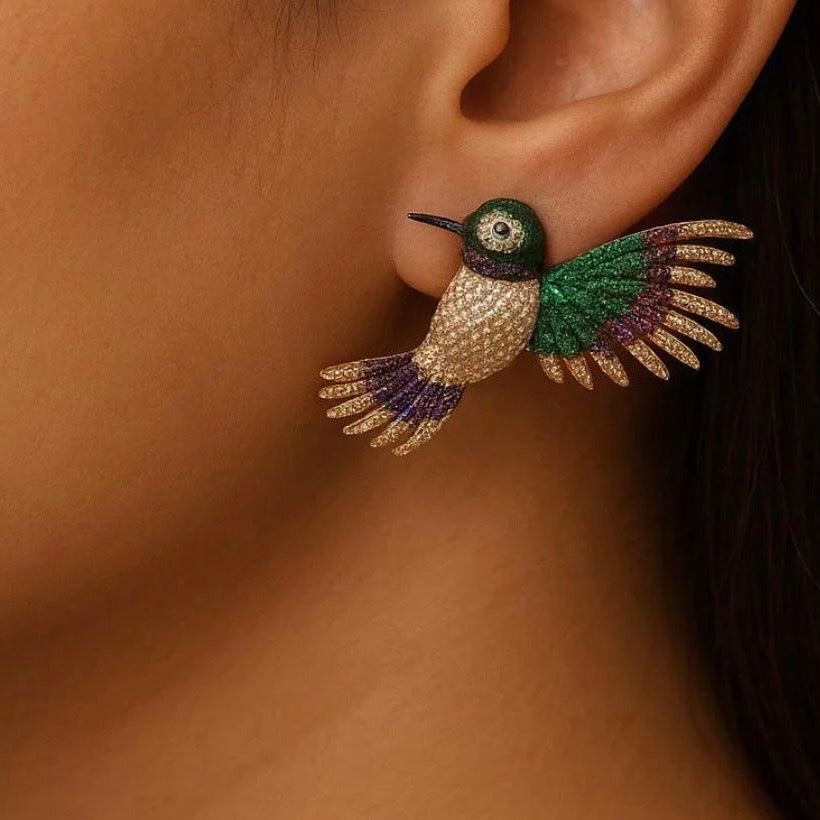 Angled shot of bird-inspired rhodium earrings with minimal setting