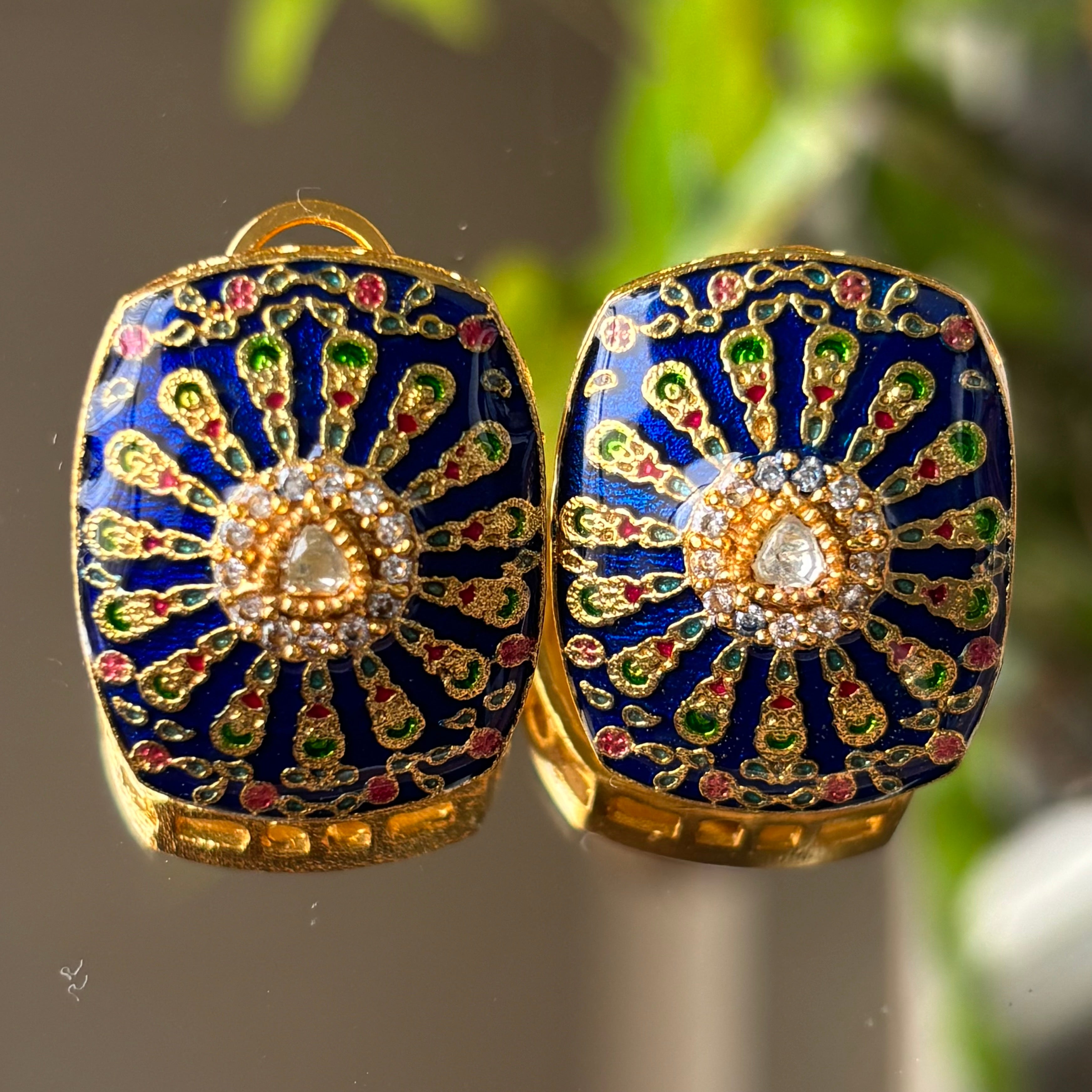 Angled view of enamelled meenakari pendant set with vibrant colors and matching earrings