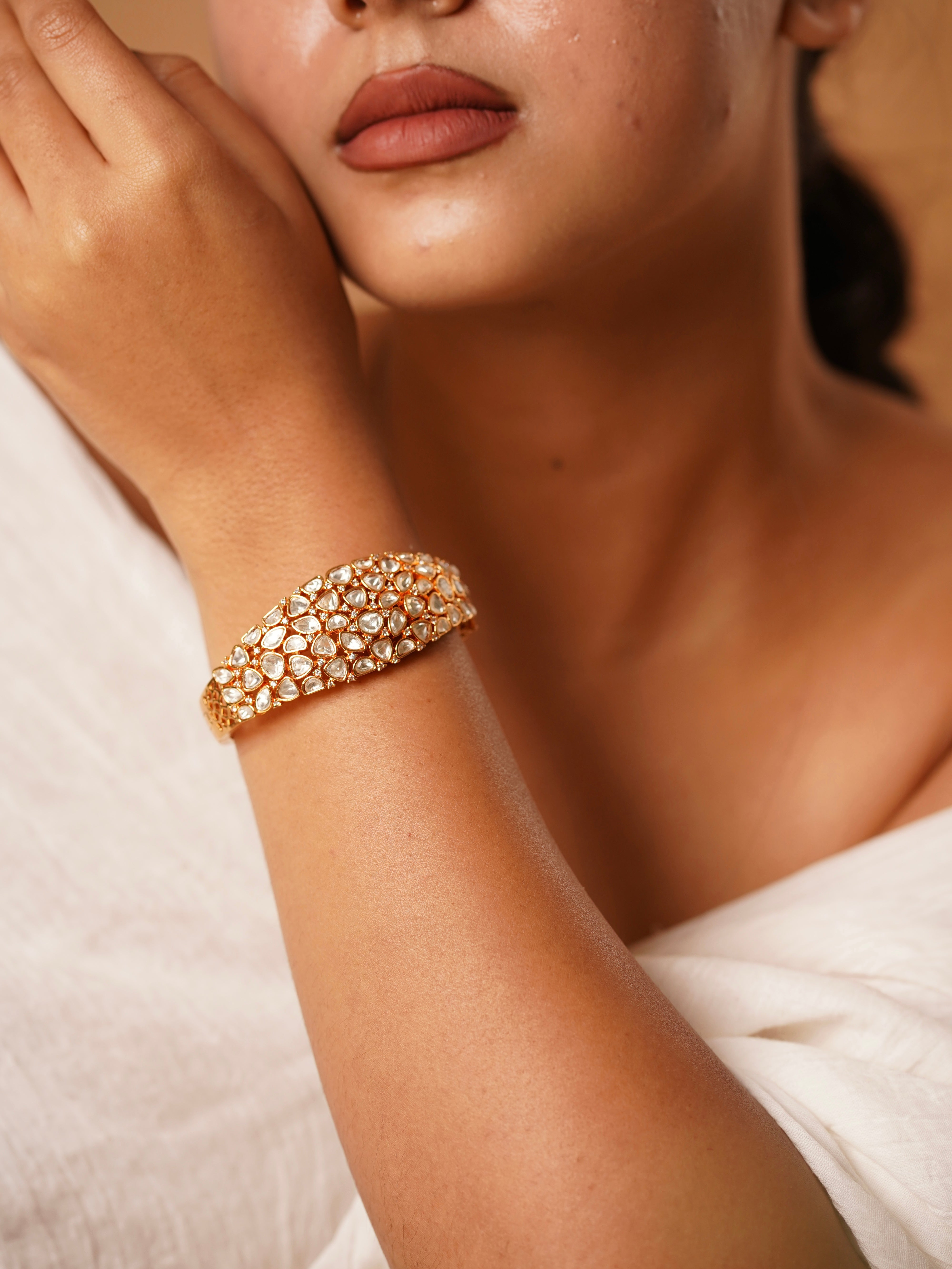 Kundan stone bracelet in gold finish with openable copper alloy frame and intricate design