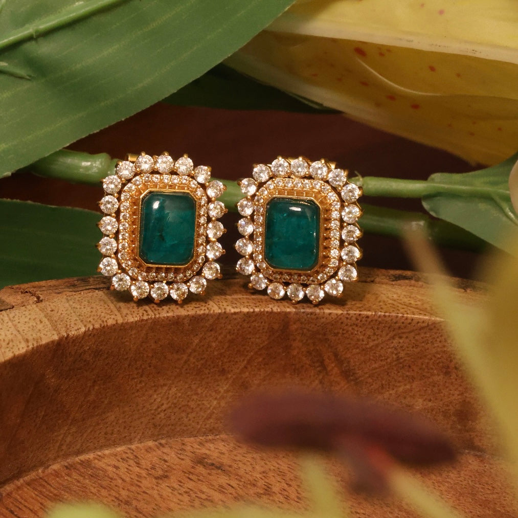 Square emerald stud earrings in gold-plated frame surrounded by clear crystal accents