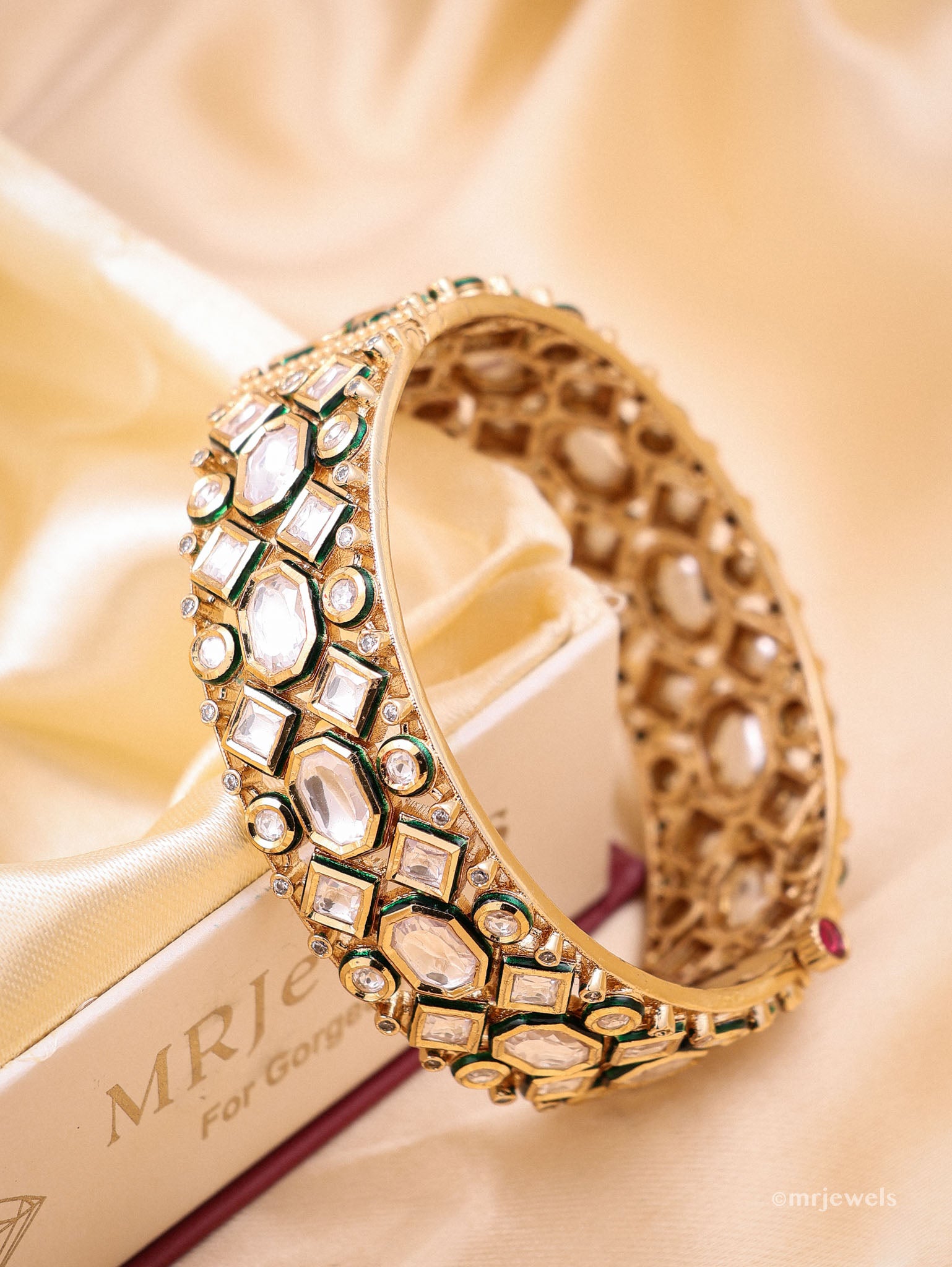 Gold bracelet with gemstones on a gold background